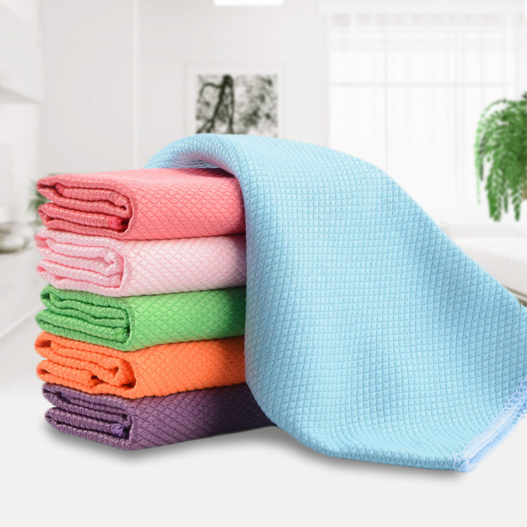 Stack of colorful folded towels on a white surface with a blurred indoor background.
